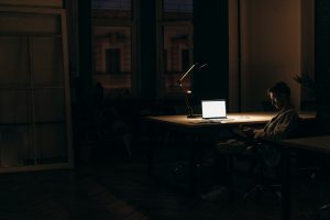 Man sitting in dark room with laptop